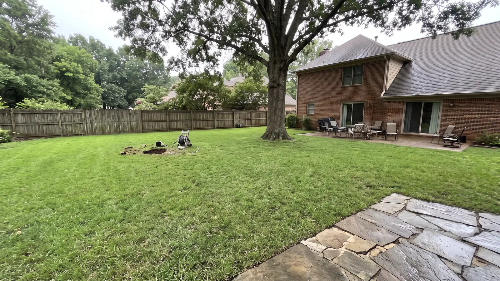 After: the same backyard intact with a single small access hole