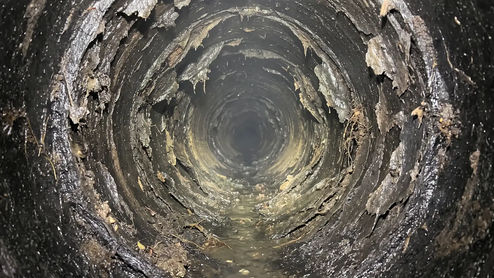 Before: a warped, flaking fiber sewer pipe